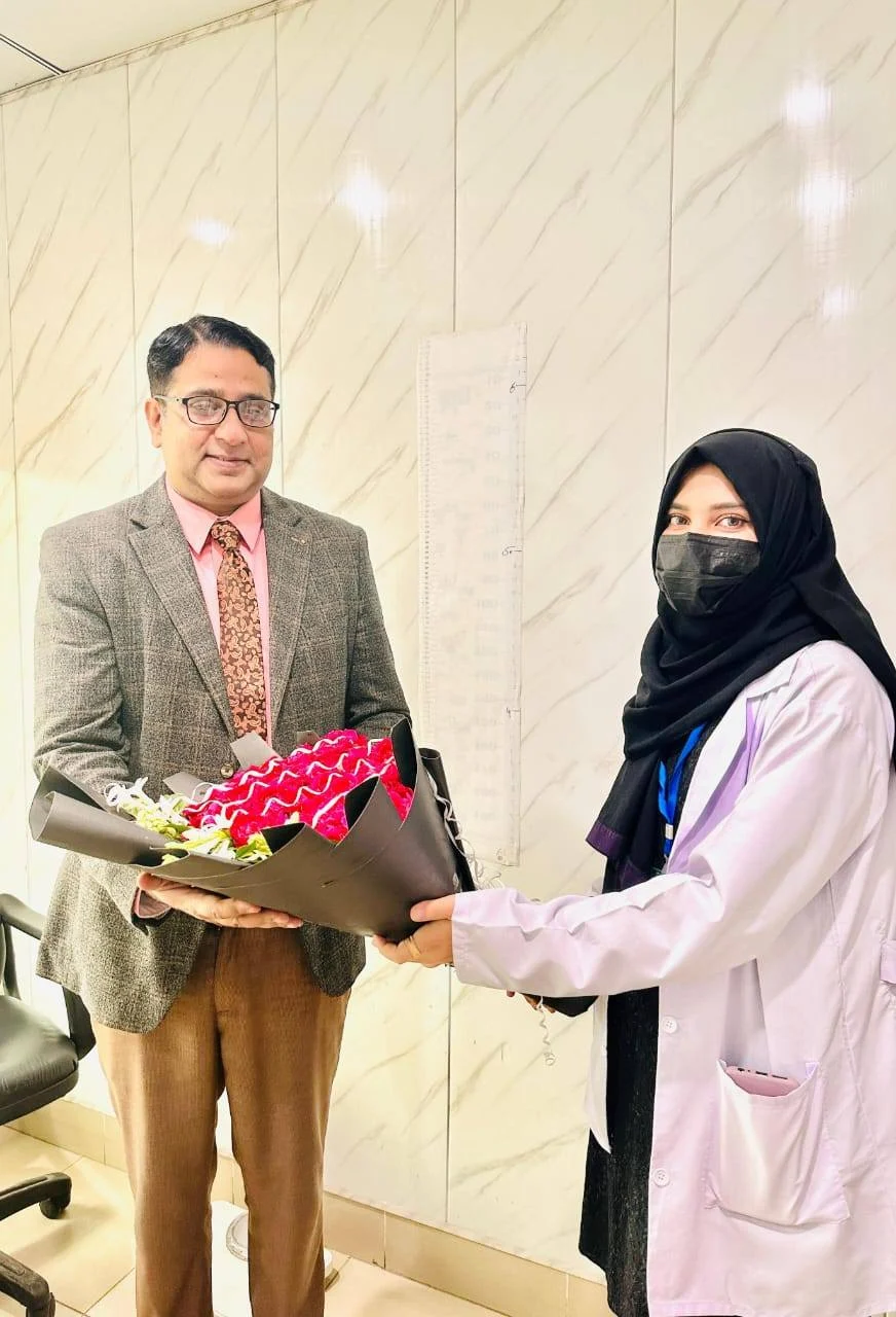 Students presenting flowers to Dr. Ahsan Tariq Dogar during an academic visit at Amaim Brain Care mental health clinic